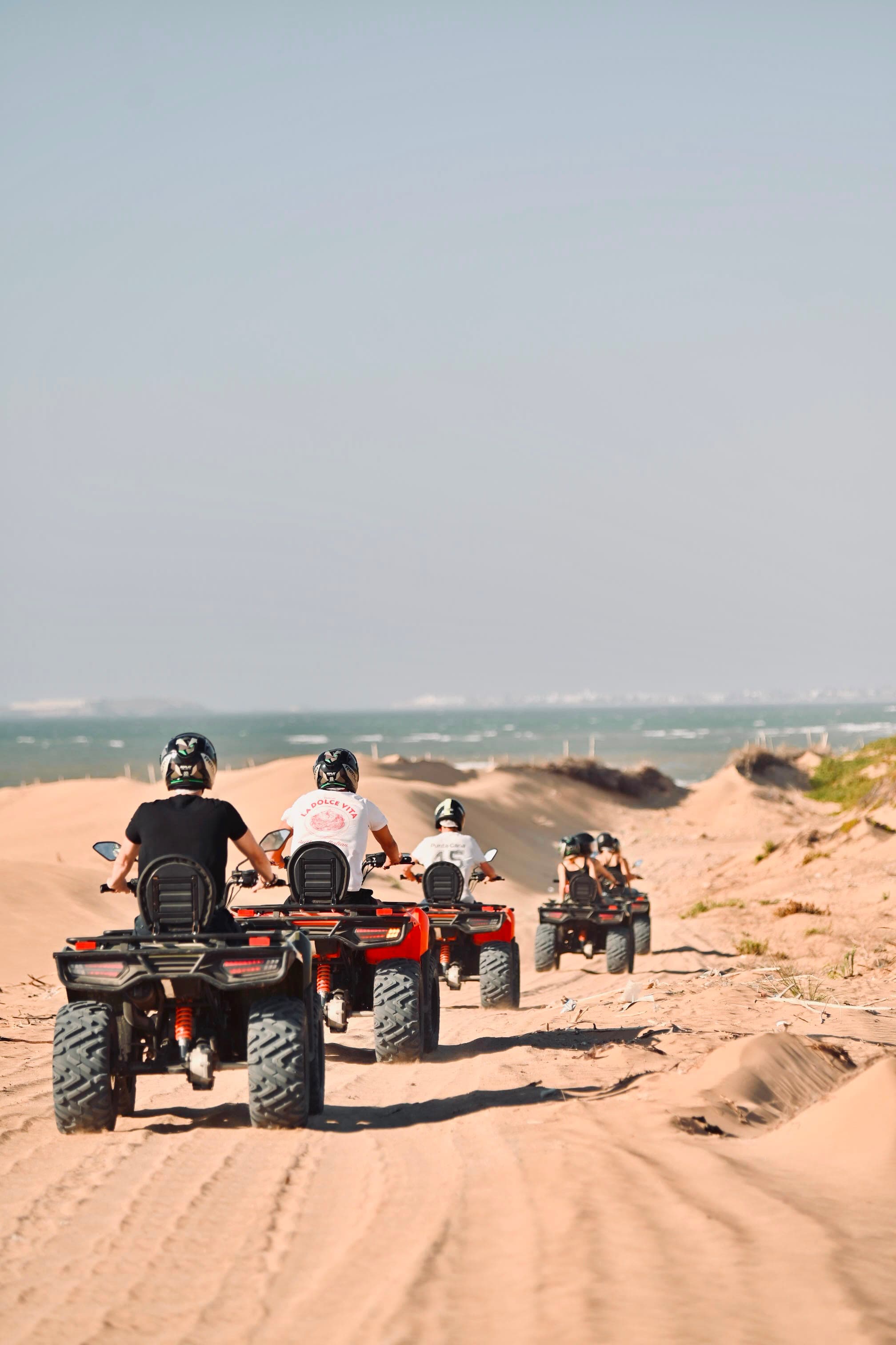 Quads riding in a line through the dunes towards the ocean near Essaouira