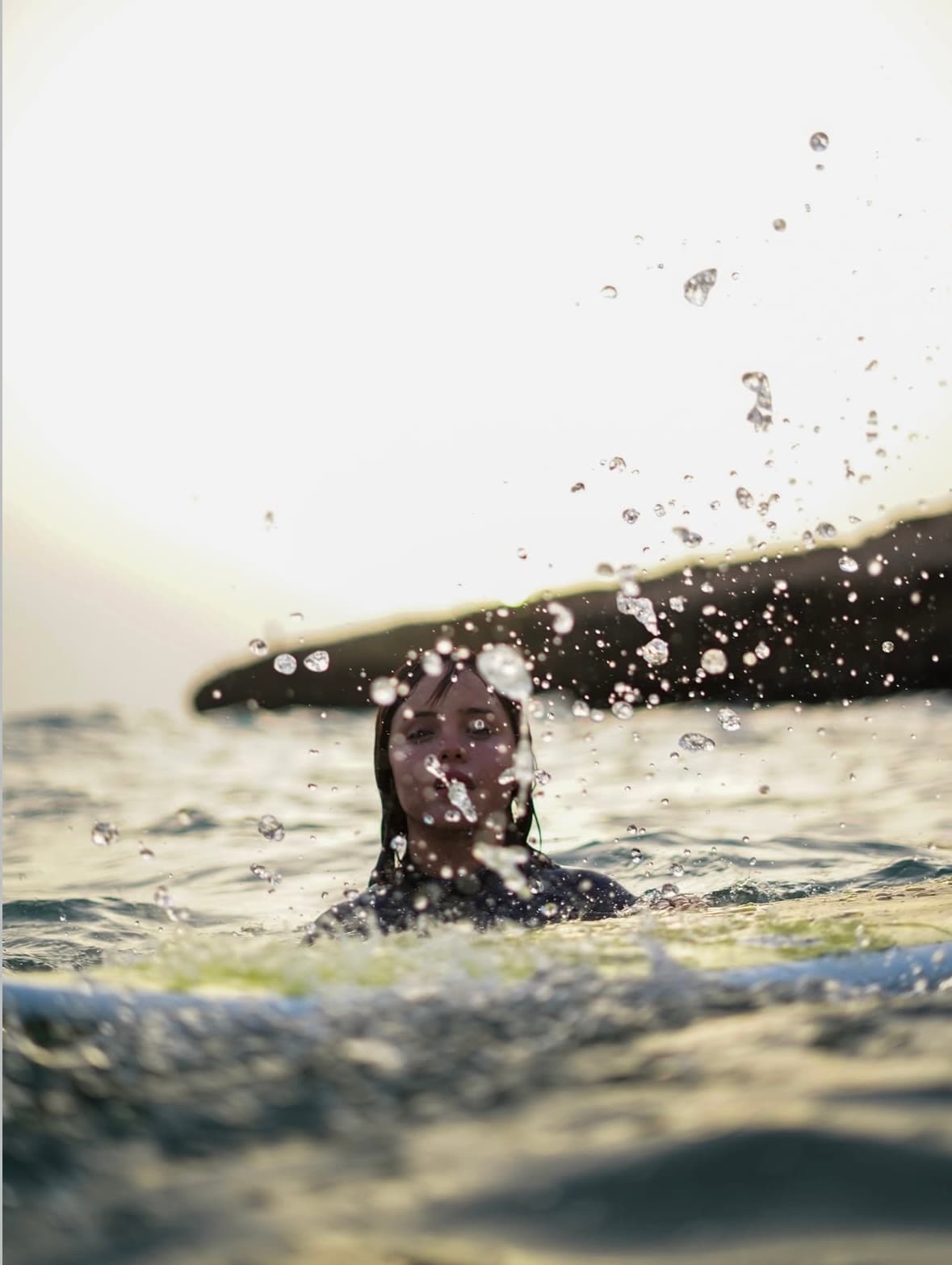 Surfer duck-diving through the water
